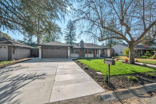 a front view of a house with a yard and trees