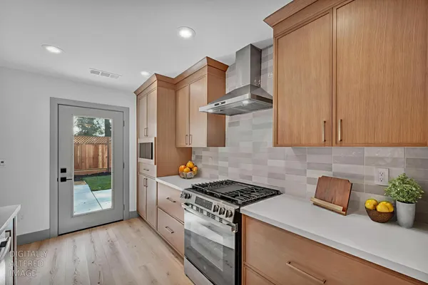 a kitchen with stainless steel appliances granite countertop a stove a sink and a refrigerator