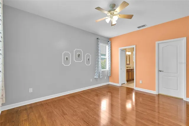 an empty room with closet and a ceiling fan