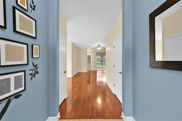 a view of a hallway with wooden floor and staircase