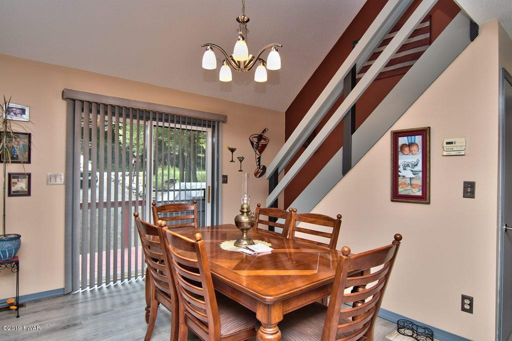 3151 Northgate Road Lake Ariel, PA 18436 - Photo 7 of 68 a dining room with wooden floor a chandelier a wooden table and chairs