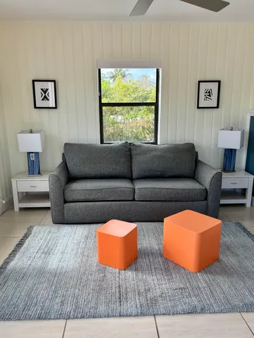a living room with blue lights with furniture and a window