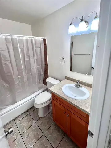 a bathroom with a toilet a sink a mirror a window and vanity