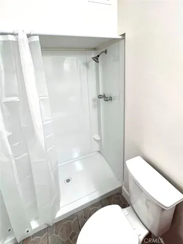 a white toilet sitting next to a bath tub