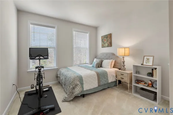 a bedroom with a bed a dresser and a flat screen tv