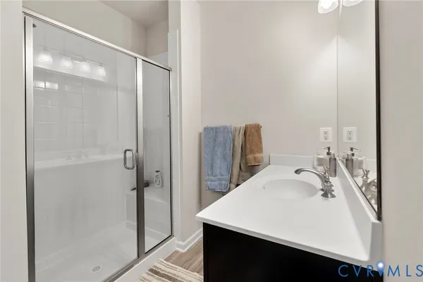 a bathroom with a sink vanity and shower