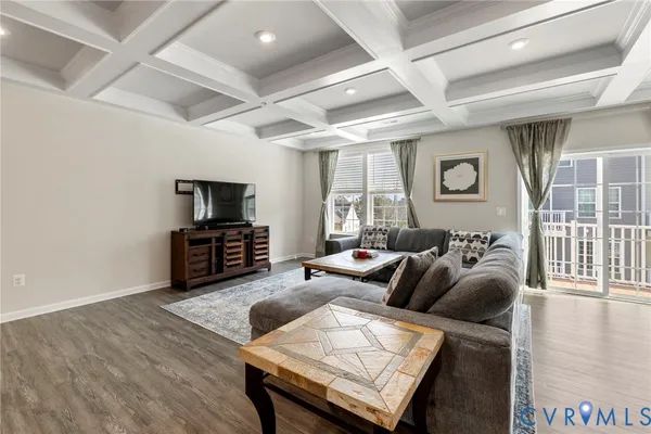 a living room with furniture a flat screen tv and a large window