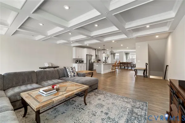 a living room with furniture and a dining table with wooden floor