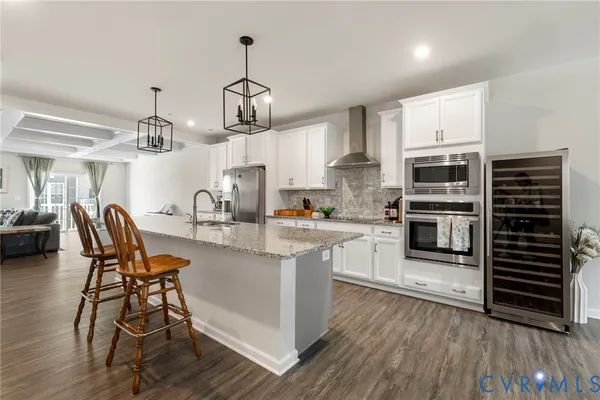 a kitchen with stainless steel appliances a dining table chairs stove and cabinets