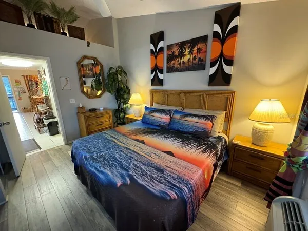 a bedroom with a bed and wooden floor