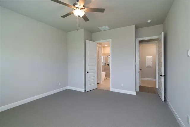 a view of an empty room and a chandelier fan