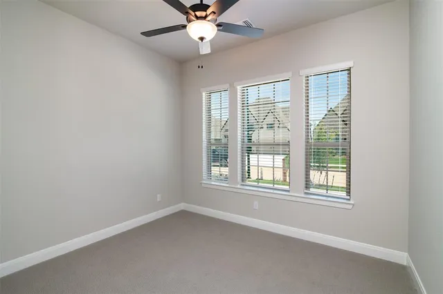 an empty room with a window and a fan