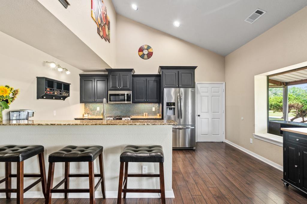 455 County Road 2808 Mabank, TX 75147 - Photo 19 of 40 a kitchen with stainless steel appliances a table chairs microwave and refrigerator