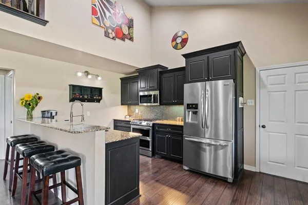 a kitchen with stainless steel appliances a refrigerator and a stove top oven