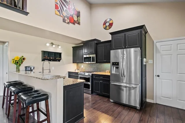 a kitchen with stainless steel appliances a refrigerator and a stove top oven