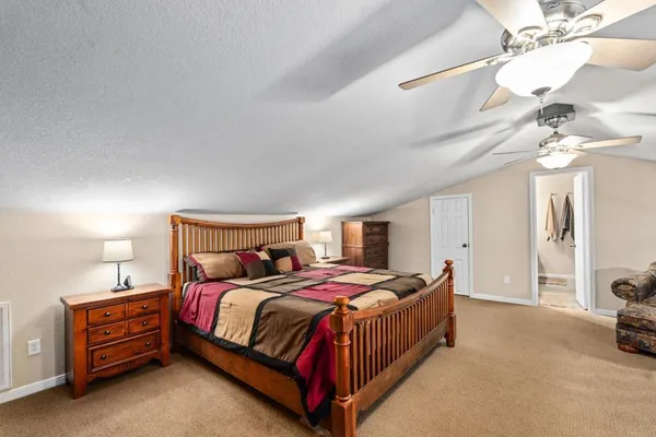 a bedroom with a bed lamp and a chandelier