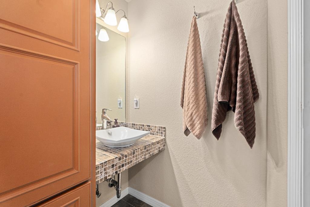 455 County Road 2808 Mabank, TX 75147 - Photo 26 of 40 a bathroom with a granite countertop sink and a mirror