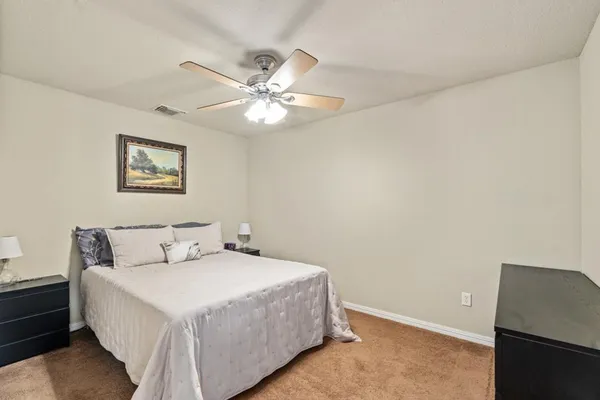 a bedroom with a large bed and a ceiling fan