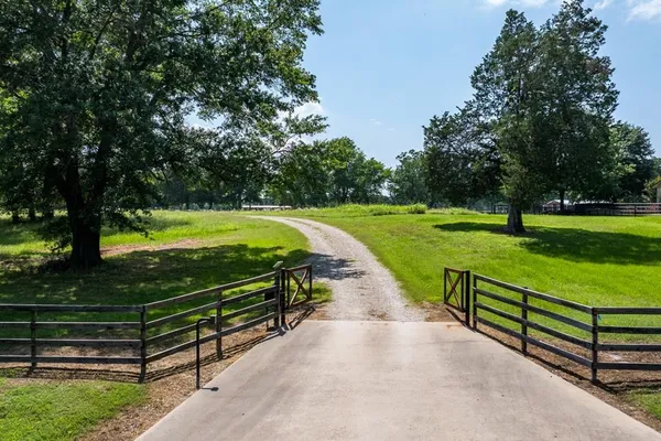 a park with wooden fence and trees