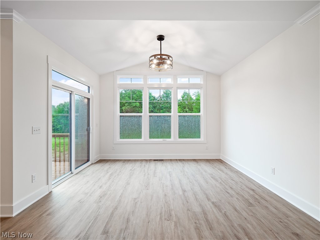 32 Brookside Lane North Ridgeville, OH 44039 - Photo 35 of 50 Unfurnished living room with light wood finished floors, healthy amount of natural light, a chandelier, and lofted ceiling