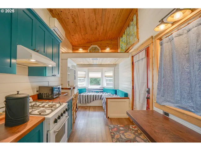 a kitchen with stainless steel appliances granite countertop a stove a sink dishwasher and a dining table with cabinets
