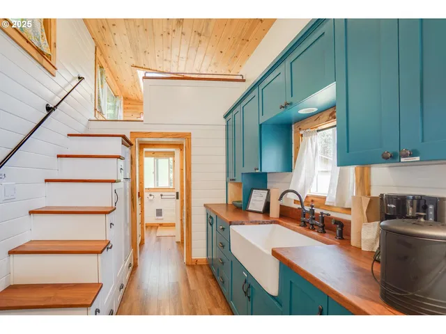 a kitchen view with wooden floor a sink and a refrigerator