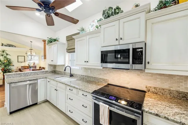 a kitchen with granite countertop a stove sink and cabinets