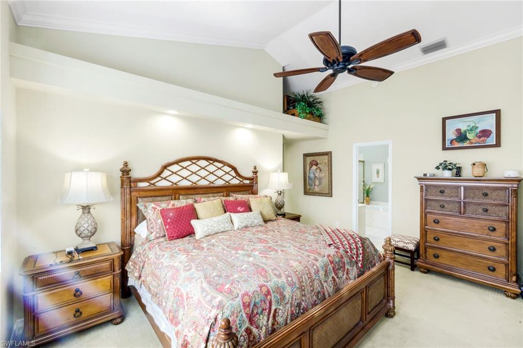 269 Perignon Place, Unit 162 Naples, FL 34119 - Photo 21 of 36 a bedroom with a bed a dresser and a chandelier