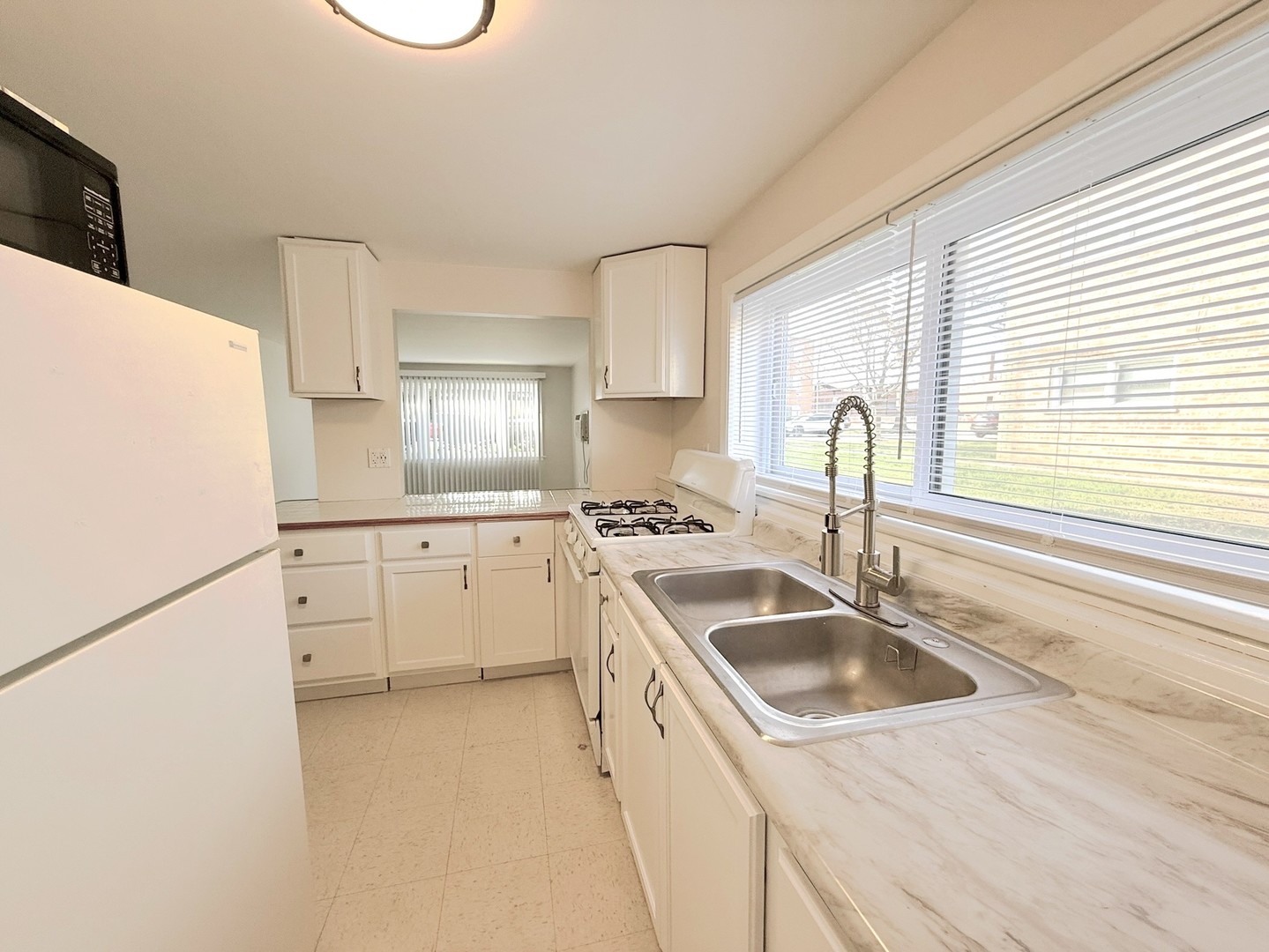 8549 Niles Center Road, Unit GN Skokie, IL 60077 - Photo 4 of 8 a kitchen that has a sink a stove and a refrigerator