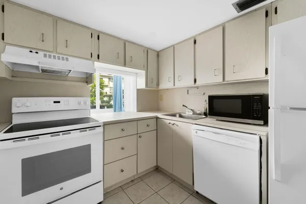 a kitchen with cabinets stainless steel appliances and sink