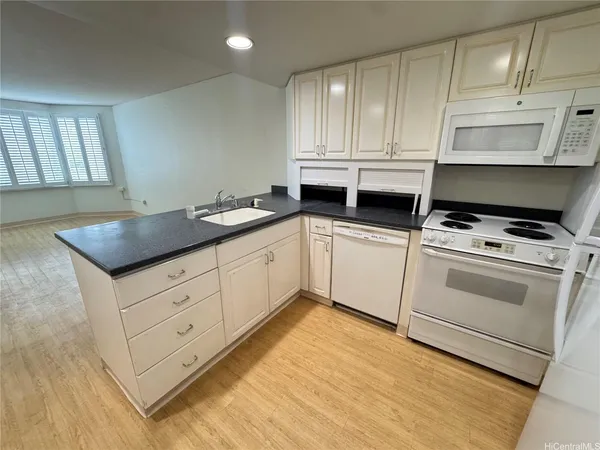 a kitchen with white cabinets appliances and a sink
