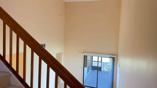 a view of staircase with railing and white walls