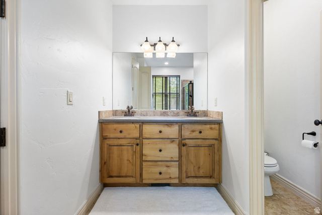 882 Sego Lily Way Mapleton, UT 84664 - Photo 17 of 41 Dual vanity with natural wood cabinetry and a stone countertop