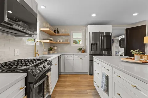 a kitchen with stainless steel appliances a sink stove and cabinets