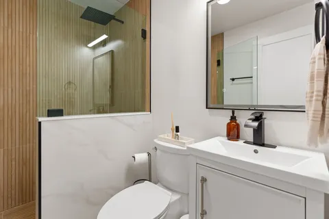 a bathroom with a toilet sink and mirror