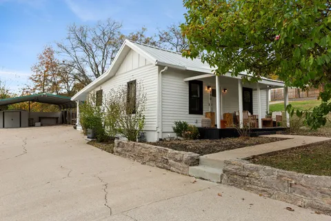 a front view of a house with a yard and potted plants