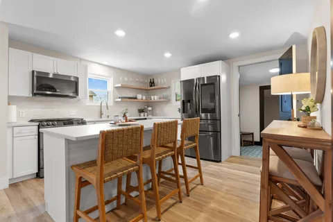a kitchen with kitchen island wooden cabinets and stainless steel appliances