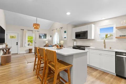 a kitchen with a dining table chairs and white cabinets