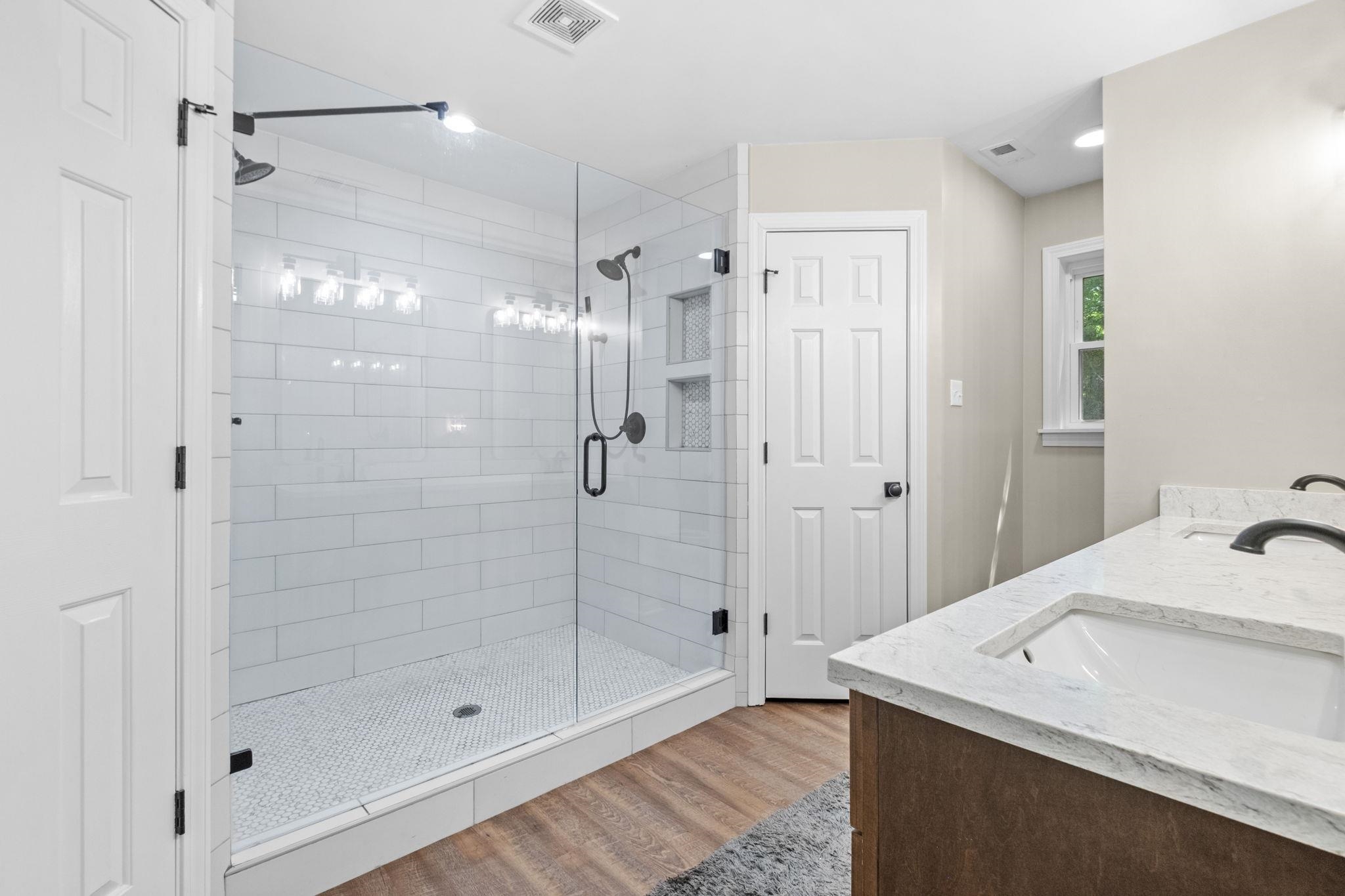 650 Firetower Road Somerville, TN 38068 - Photo 20 of 39 Full bath with double vanity, light wood finished floors, and a shower stall