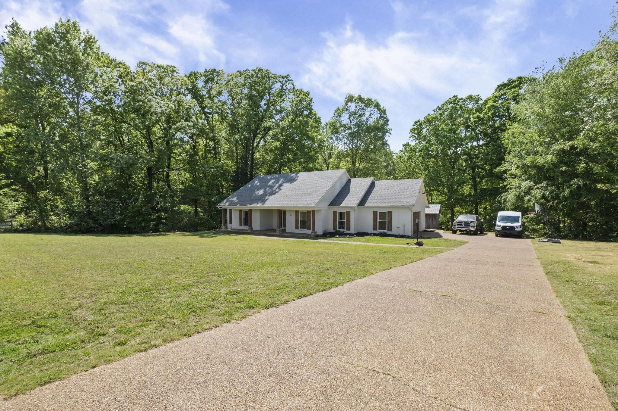 650 Firetower Road Somerville, TN 38068 - Photo 32 of 39 Ranch-style house featuring a front yard, asphalt driveway, and view of wooded area