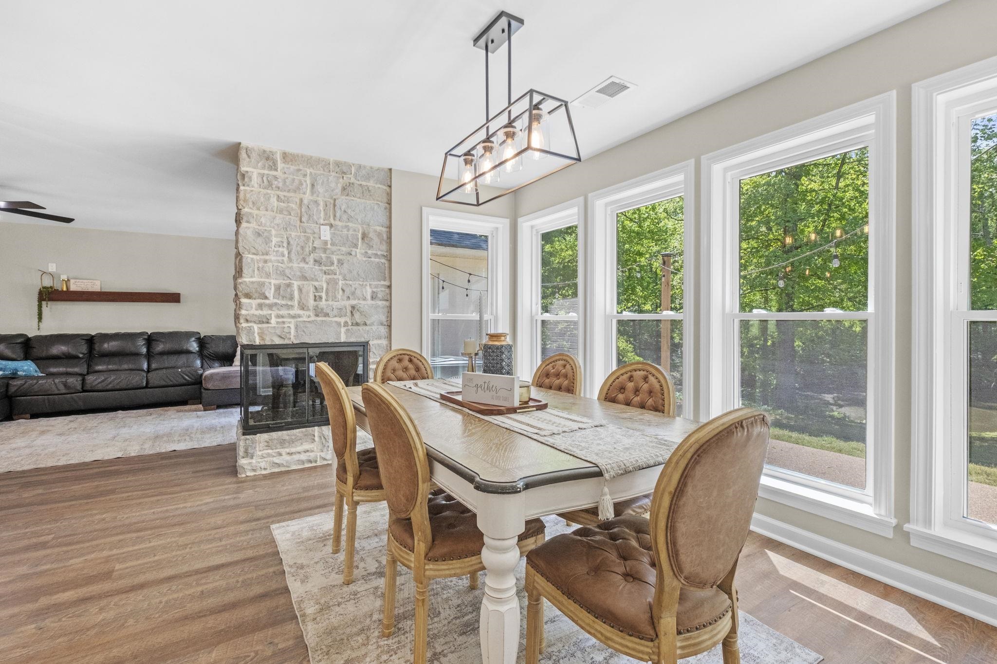 650 Firetower Road Somerville, TN 38068 - Photo 8 of 39 Dining space featuring a stone fireplace, wood finished floors, and a chandelier