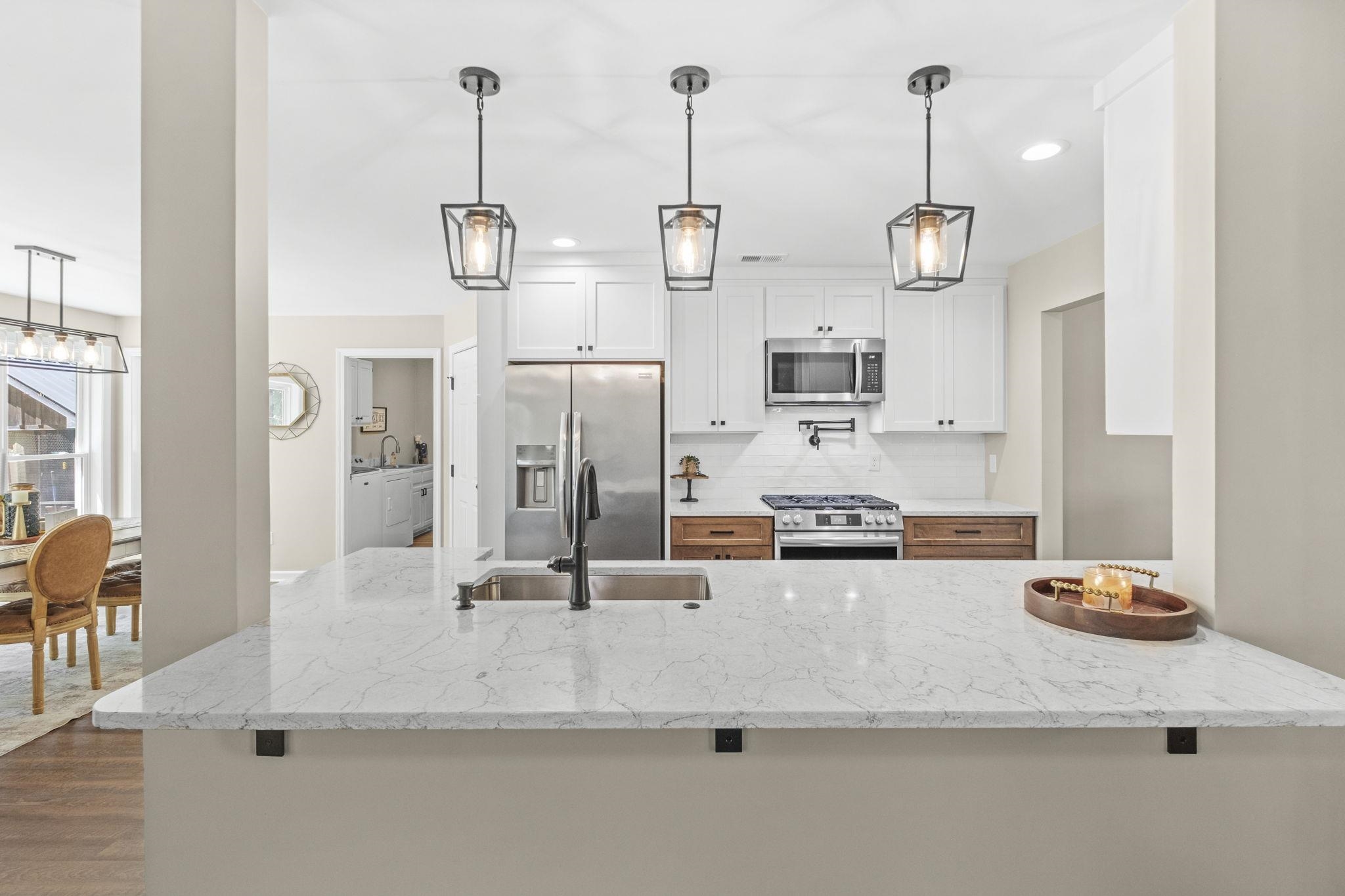 650 Firetower Road Somerville, TN 38068 - Photo 9 of 39 Kitchen with white cabinets, light stone countertops, stainless steel appliances, pendant lighting, and decorative backsplash