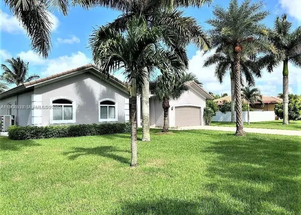 a house with palm trees next to a yard