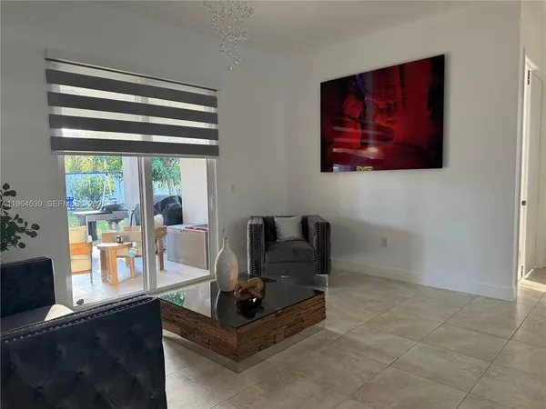 a living room with furniture and a floor to ceiling window