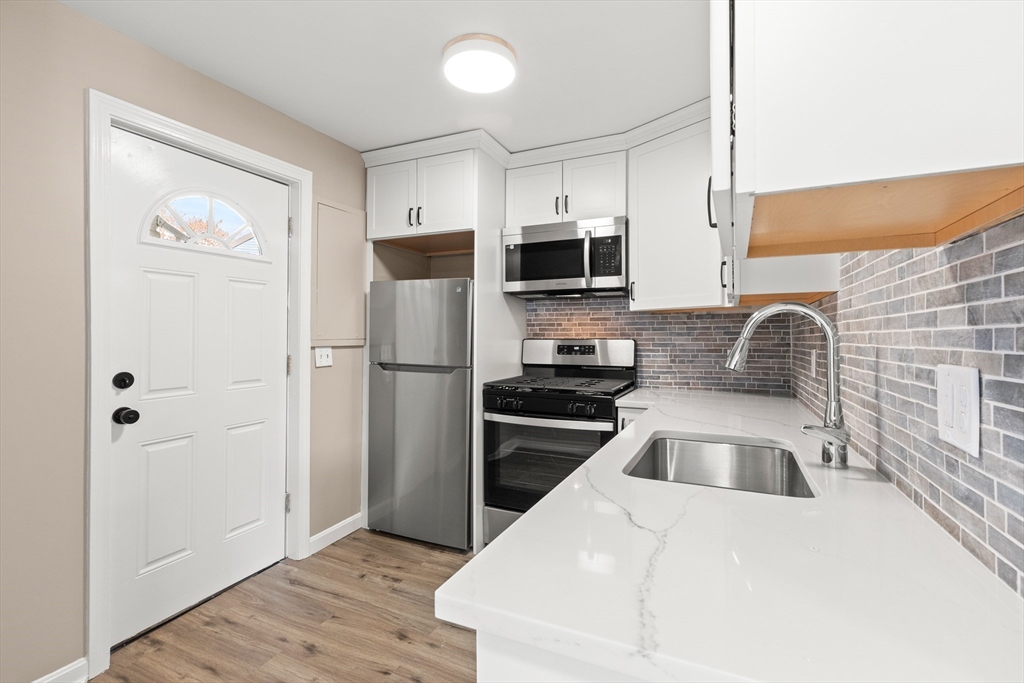 141 Prospect Street Gloucester, MA 01930 - Photo 17 of 32 a kitchen with stainless steel appliances a refrigerator sink and microwave