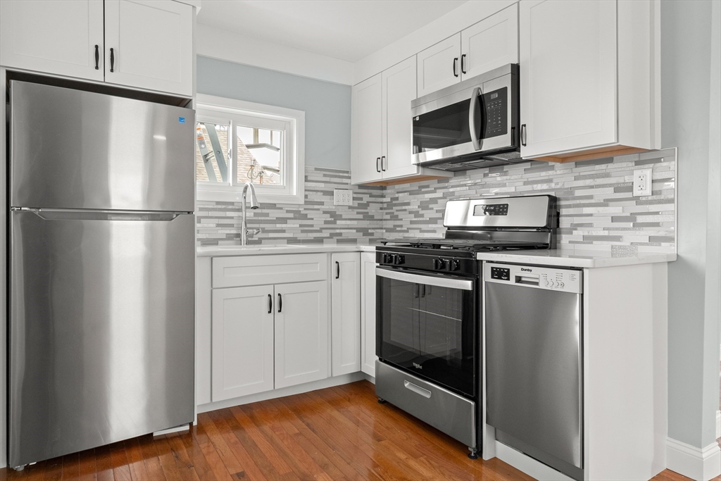 141 Prospect Street Gloucester, MA 01930 - Photo 3 of 32 a kitchen with stainless steel appliances a stove microwave and refrigerator