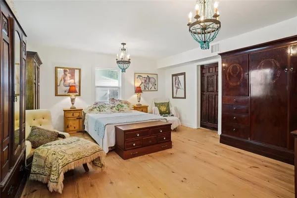 a spacious bedroom with a bed and a chandelier