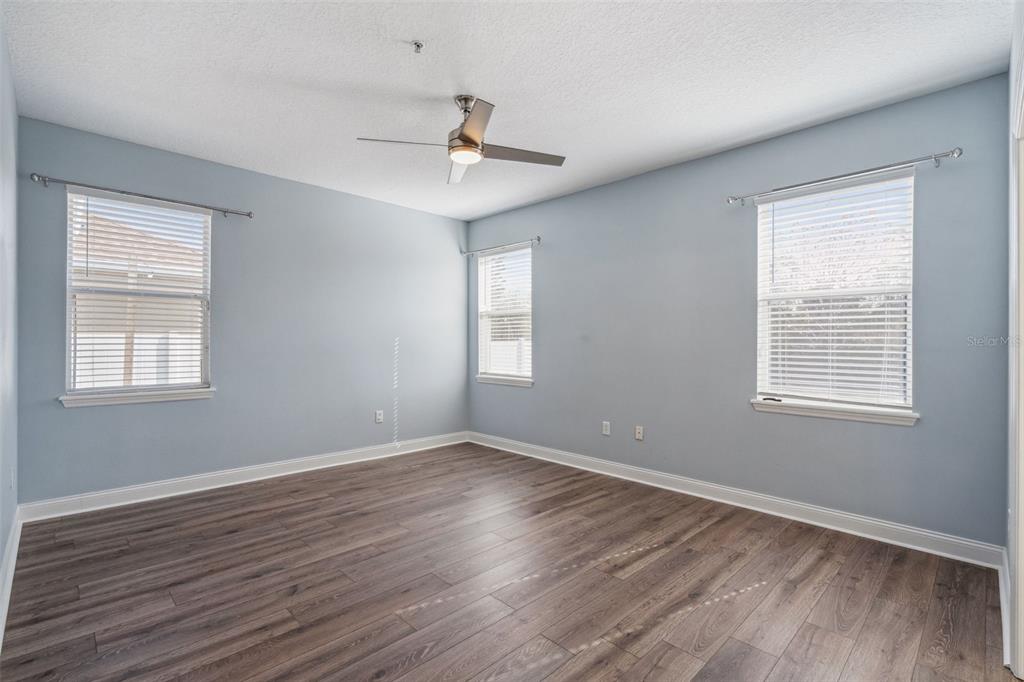 10544 Moss Rose Way Orlando, FL 32832 - Photo 13 of 40 a view of an empty room with wooden floor and a window