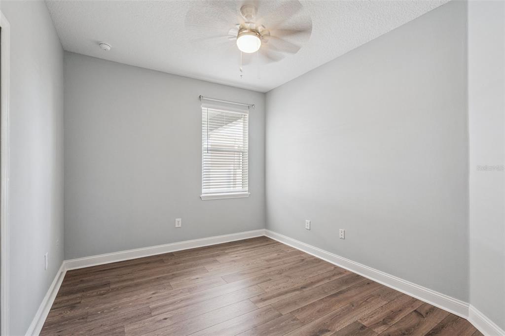 10544 Moss Rose Way Orlando, FL 32832 - Photo 20 of 40 an empty room with wooden floor and a window