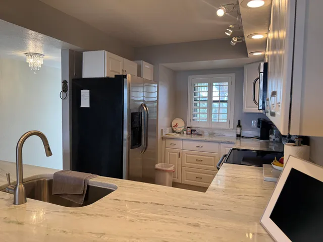 a kitchen with stainless steel appliances granite countertop a stove a sink and a microwave